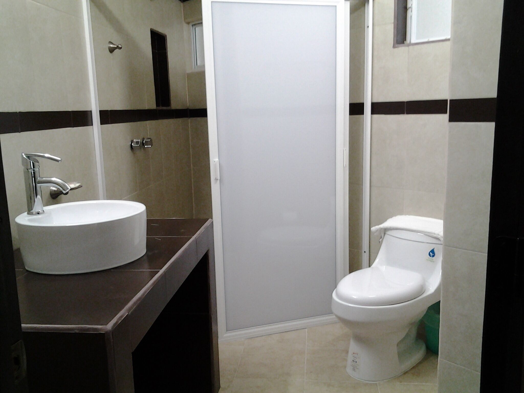 A bathroom with a white sink, a toilet, and a door.