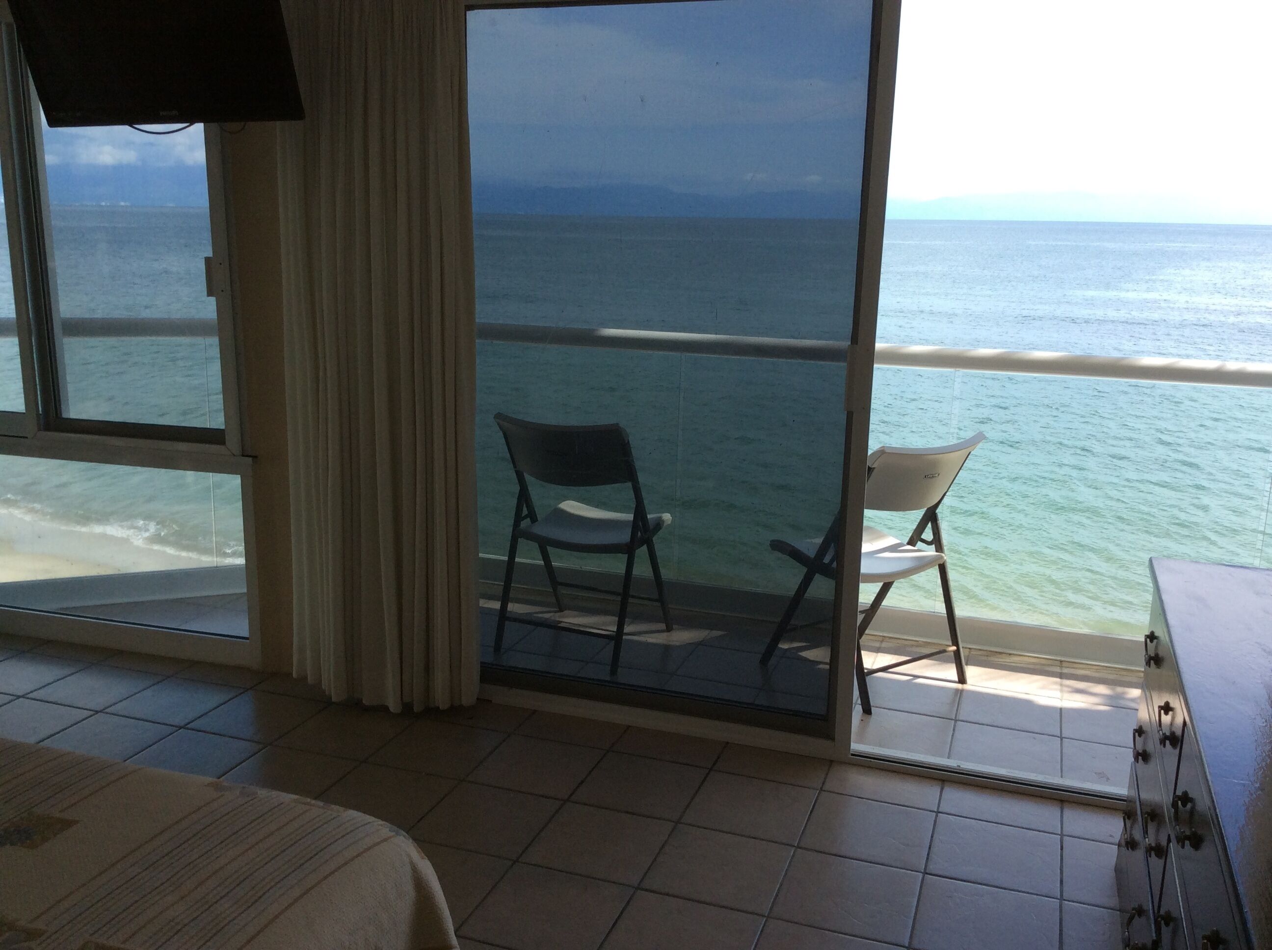 Un balcon avec deux chaises donnant sur la mer.