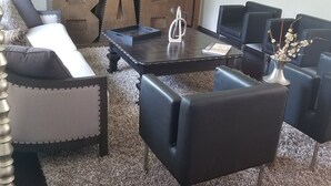 A modern living room with a sofa, armchairs, a coffee table, and a decorative cabinet. - Catskills Modern Comfort Home Mountainous Backdrop (East Branch)