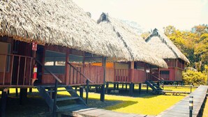 Thatched-roof huts with wooden railings and a wooden walkway.