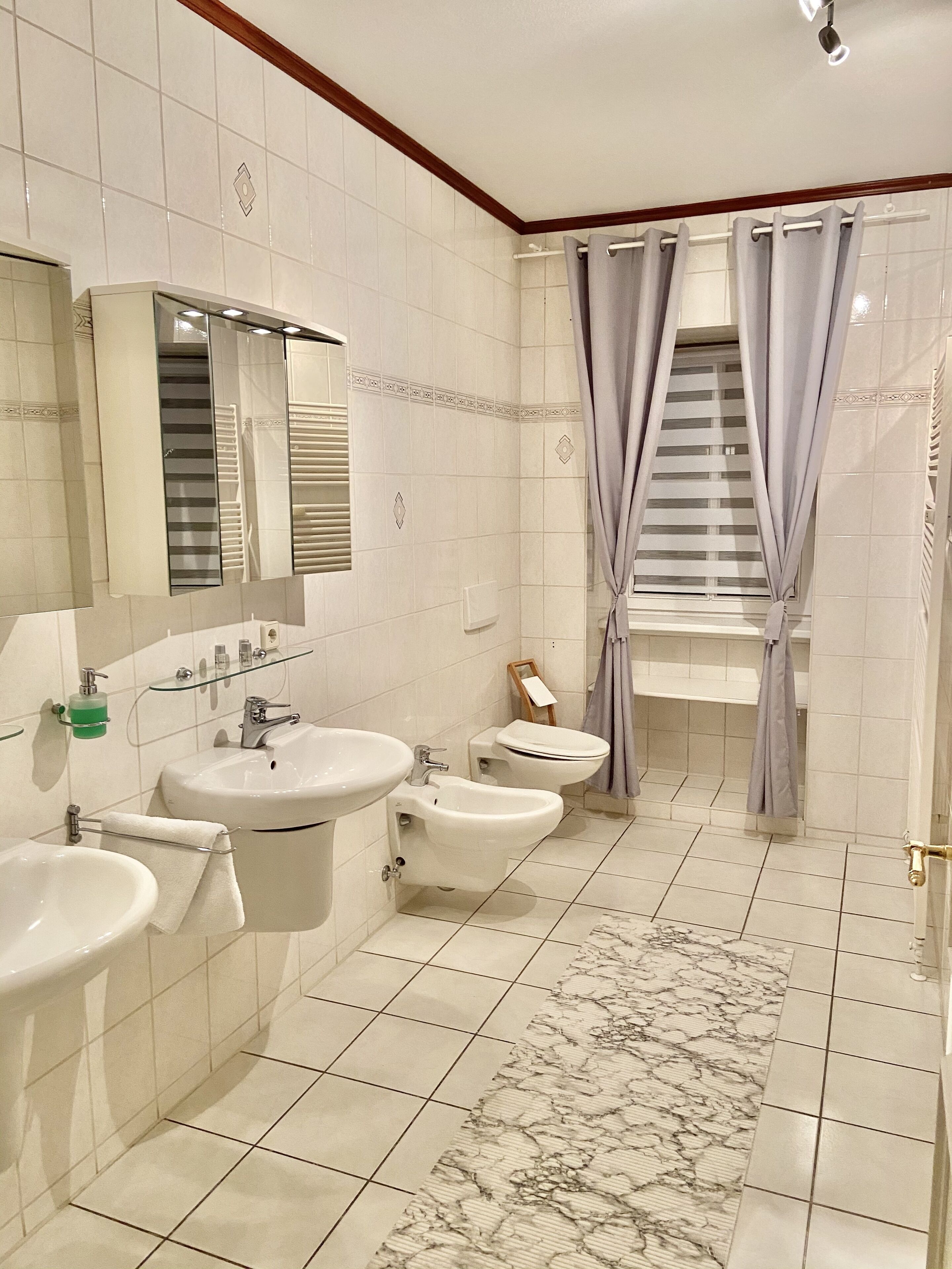 Ein Badezimmer mit zwei Waschbecken, einem Bidet und einer Toilette.