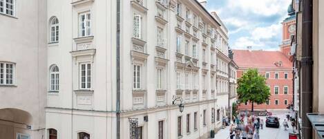 A historic building with classical architecture, a museum sign, and a street with pedestrians.