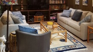 A cozy living room with a high ceiling, skylights, a fireplace, a bookshelf, a television, and a comfortable seating area. - Big house, big yard, close to everything in Mount Gretna! (Mt Gretna)