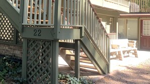 A covered outdoor deck with a staircase leading to a second level, a picnic table, and a garage door. - Big house, big yard, close to everything in Mount Gretna! (Mt Gretna)