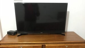 A wooden dresser with a flat-screen TV on top. - Hospedaje Las Flores (Trujillo)