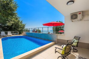 Una piscina al aire libre de temporada, sillones reclinables de piscina
