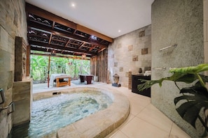 A spa area with a hot tub, stone walls, and a wooden ceiling.