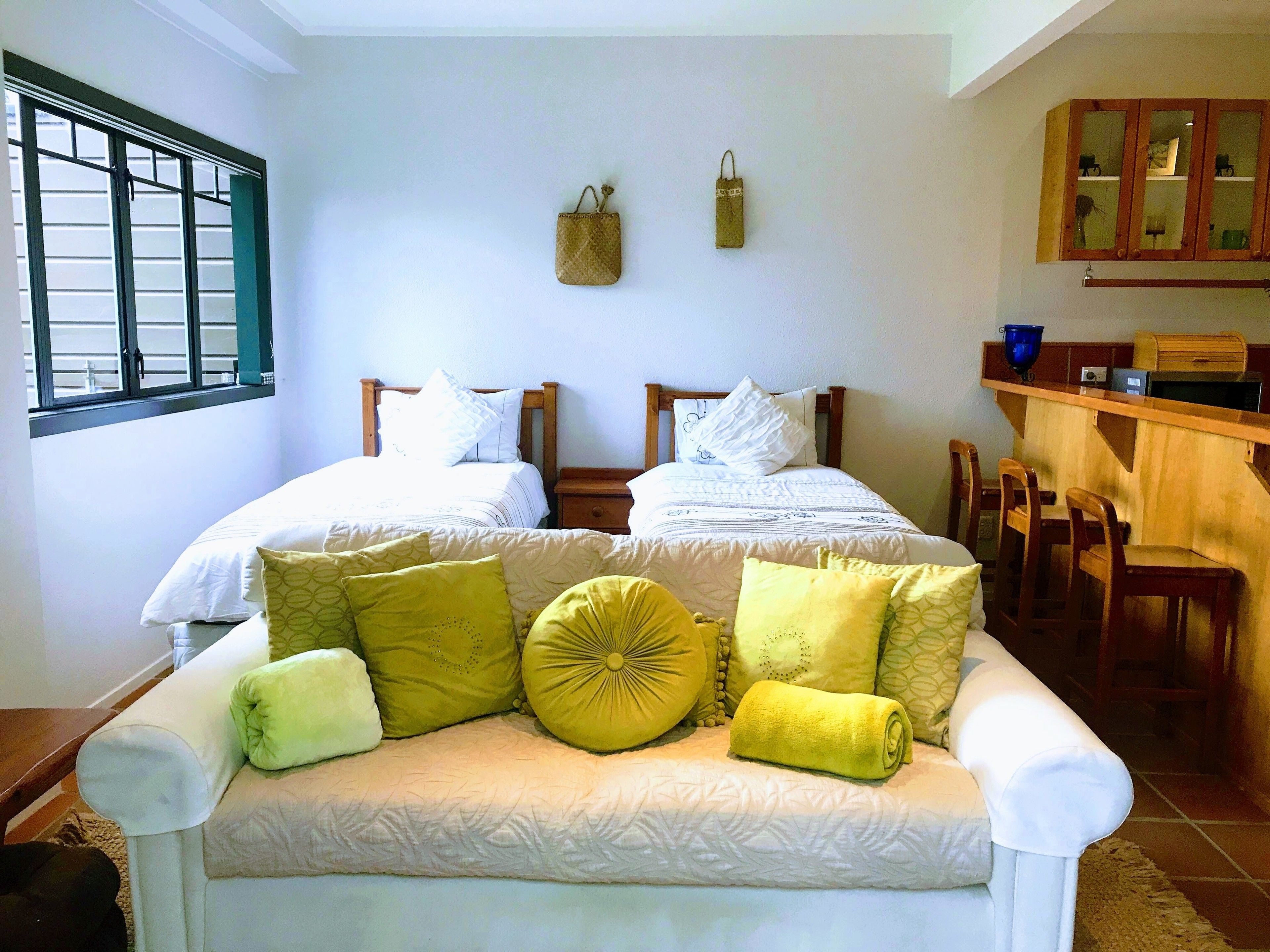 A double room with two beds, a sofa, and a small kitchen area.
