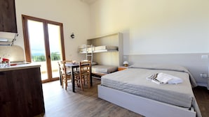 A bedroom with a bed, a desk with chairs, a window, and a view of the outdoors. - La Cerqua (Arcevia)