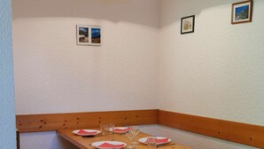 Ein Essbereich in der Ecke mit Holzbänken und einem Tisch für vier Personen.