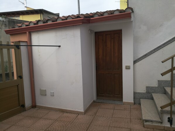 A small, enclosed outdoor area with a tiled floor, a wooden door, and a metal gate. - Casa Mannu Fluminimaggiore - Authentic home in the historic village center (Fluminimaggiore)