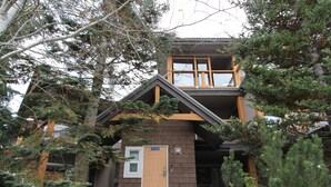 A two-story building with a brown exterior, a wooden balcony, and a door labeled "Entrance."