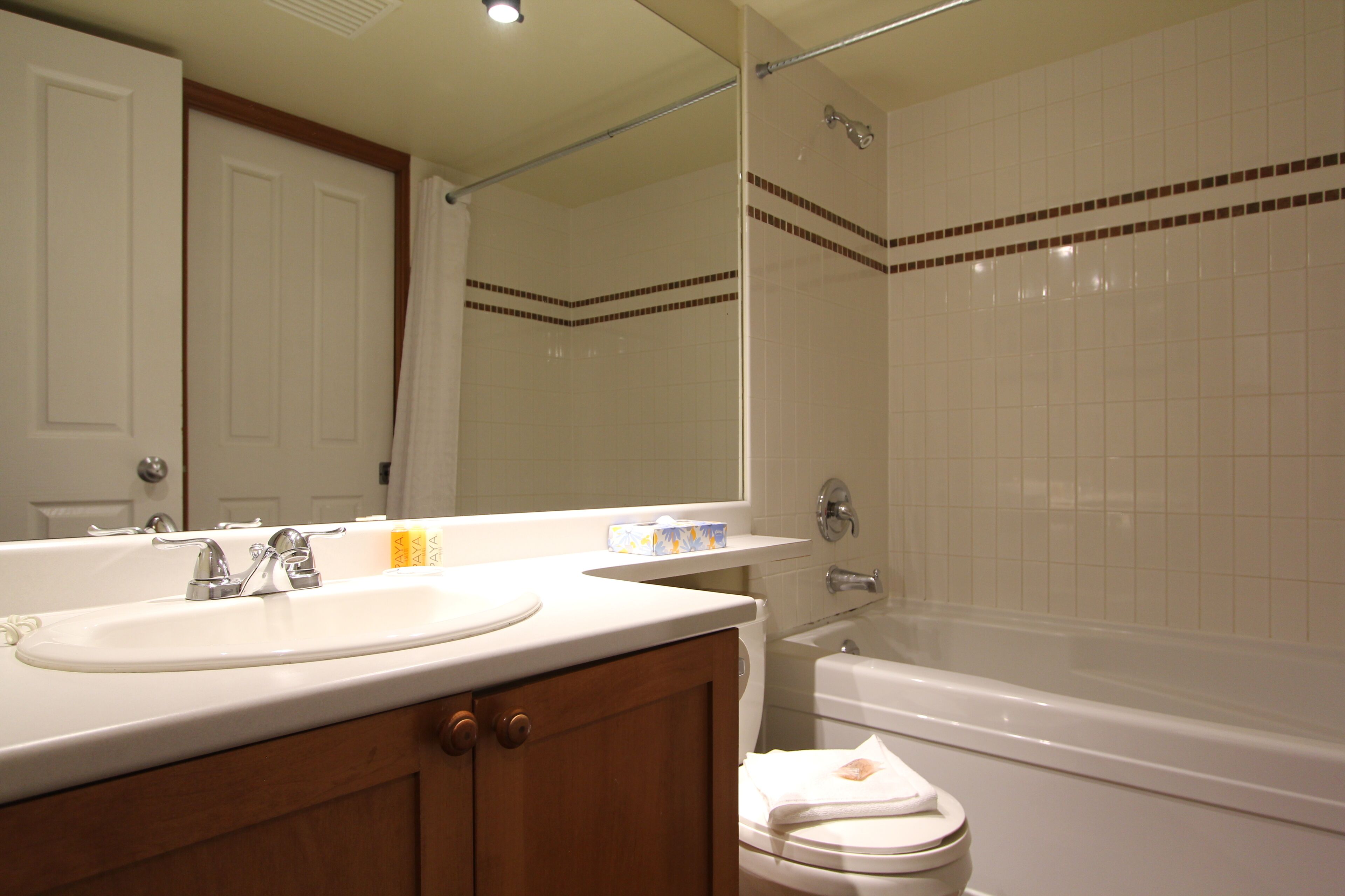 A bathroom with a sink, mirror, toilet, and bathtub.