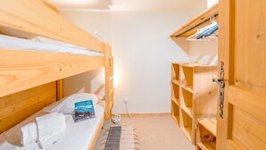 A bunk bed room with a bedside table, a book, and a power outlet. - Grand Roc C322 280m from Slopes, Parking & WiFi, Argentière (Chamonix), France (Argentière (Chamonix))