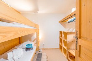 A bunk bed room with a bedside table, a book, and a power outlet. - Grand Roc C322 280m from Slopes, Parking & WiFi, Argentière (Chamonix), France (Argentière (Chamonix))