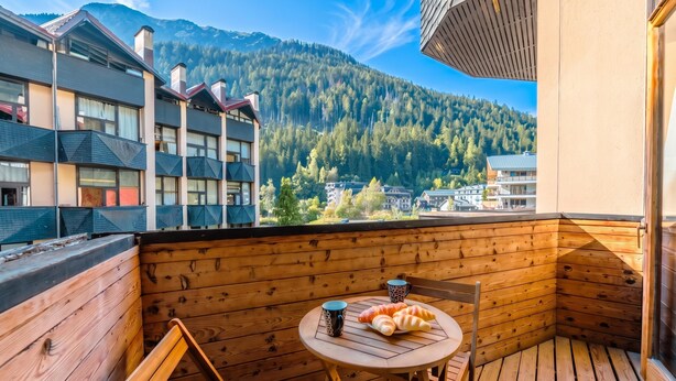 A wooden deck with a table and chairs, a croissant basket, and a mug. - Grand Roc C322 280m from Slopes, Parking & WiFi, Argentière (Chamonix), France (Argentière (Chamonix))