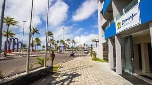 A hotel with a blue and white facade, palm trees, and a clear sky. - Beira Mar Hotel (Aracaju)
