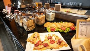 A buffet with various food items, including a sandwich and a plate of pizza slices. - Beira Mar Hotel (Aracaju)