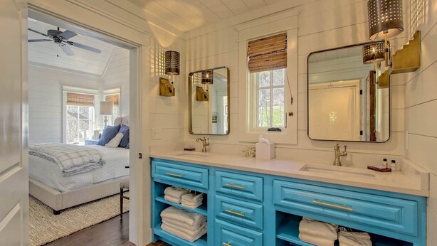 A bathroom with two sinks, a mirror, and a ceiling fan.