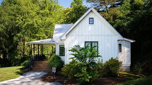A white single-story house with a porch, a small window, and a sign that reads "B&B."