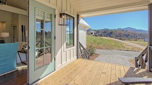 A wooden deck with a view of a hilly landscape.