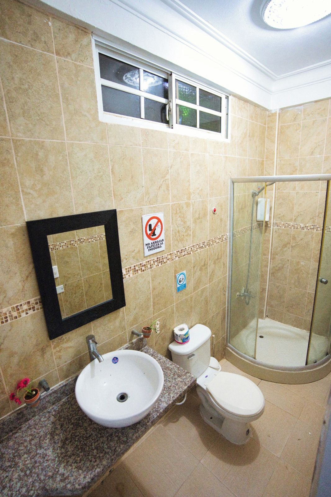A bathroom with a sink, toilet, and glass-enclosed shower.