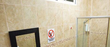 A bathroom with a sink, toilet, and glass-enclosed shower.