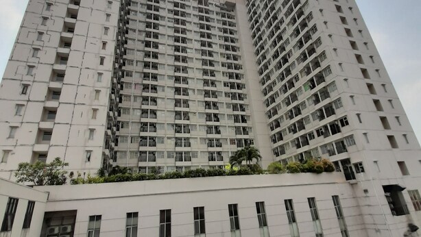 Un edificio residencial de gran altura con varios balcones, techo plano y una estructura de cúpula central.