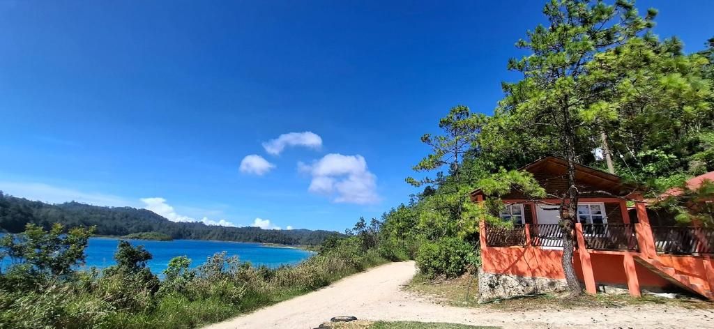 Una cabaña con vistas a un lago y bosque.
