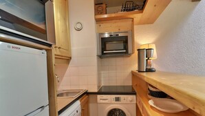 A compact kitchen with a Bosch refrigerator, a washing machine, a microwave, and a coffee maker. - Family duplex on the slopes, ideal for 7 people (Méribel)