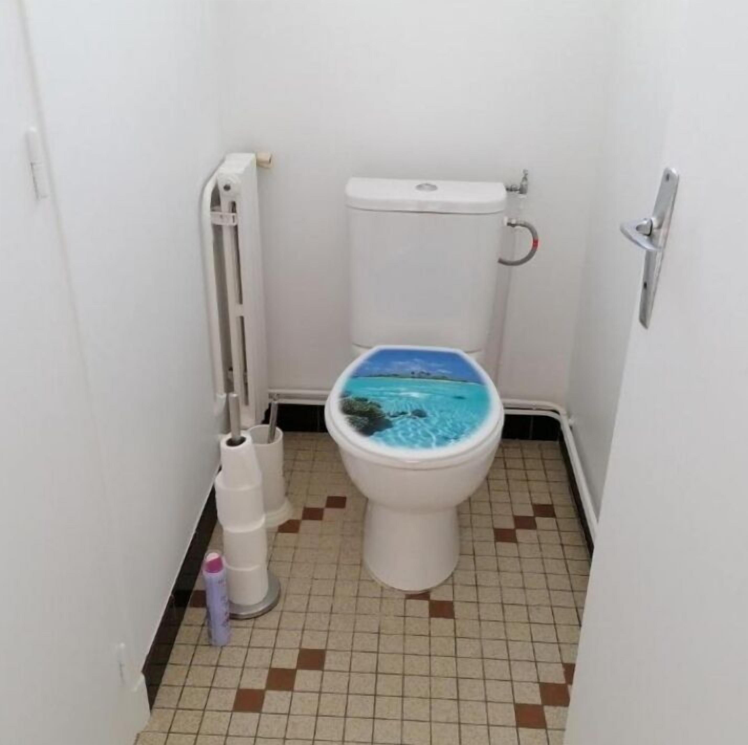A small bathroom with a toilet, a radiator, and a tiled floor.