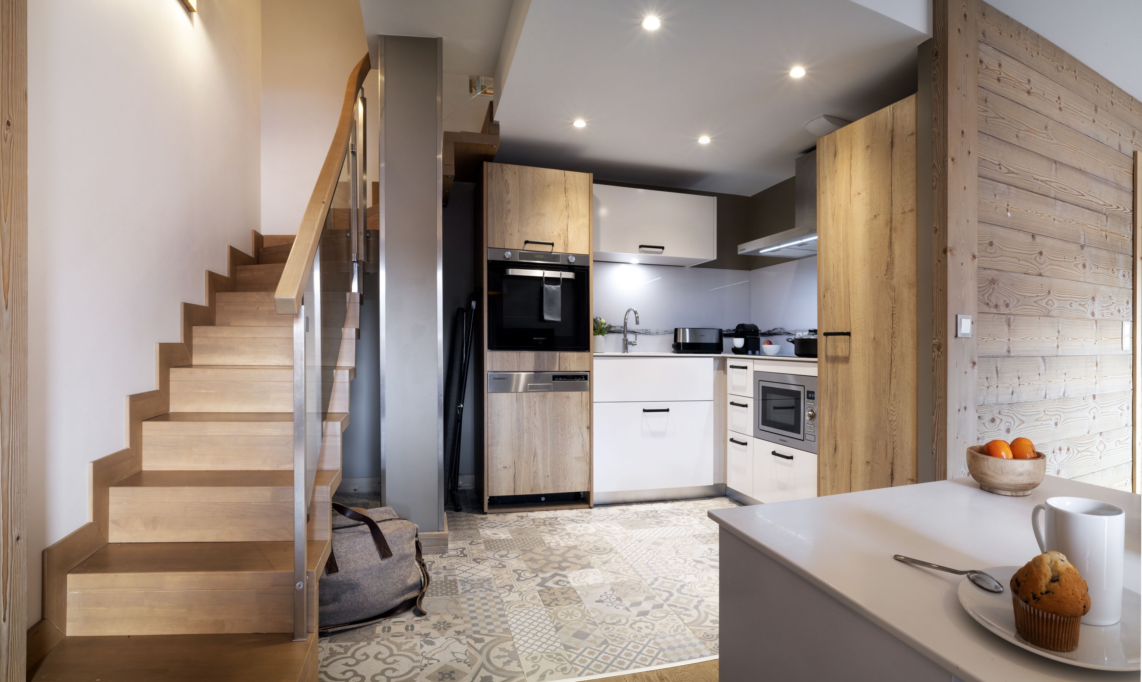 A modern kitchen with wooden cabinetry, stainless steel appliances, and a built-in oven.