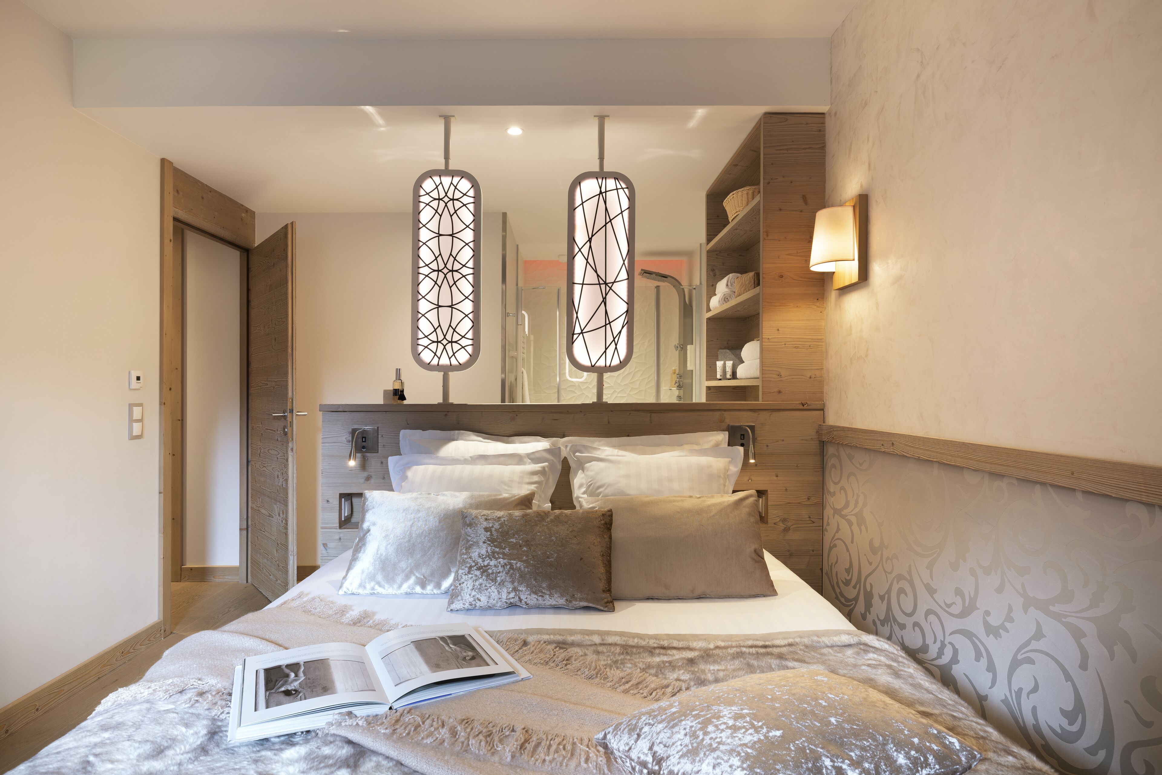 Une chambre à coucher moderne avec un grand lit, une table de chevet, un miroir et une armoire.