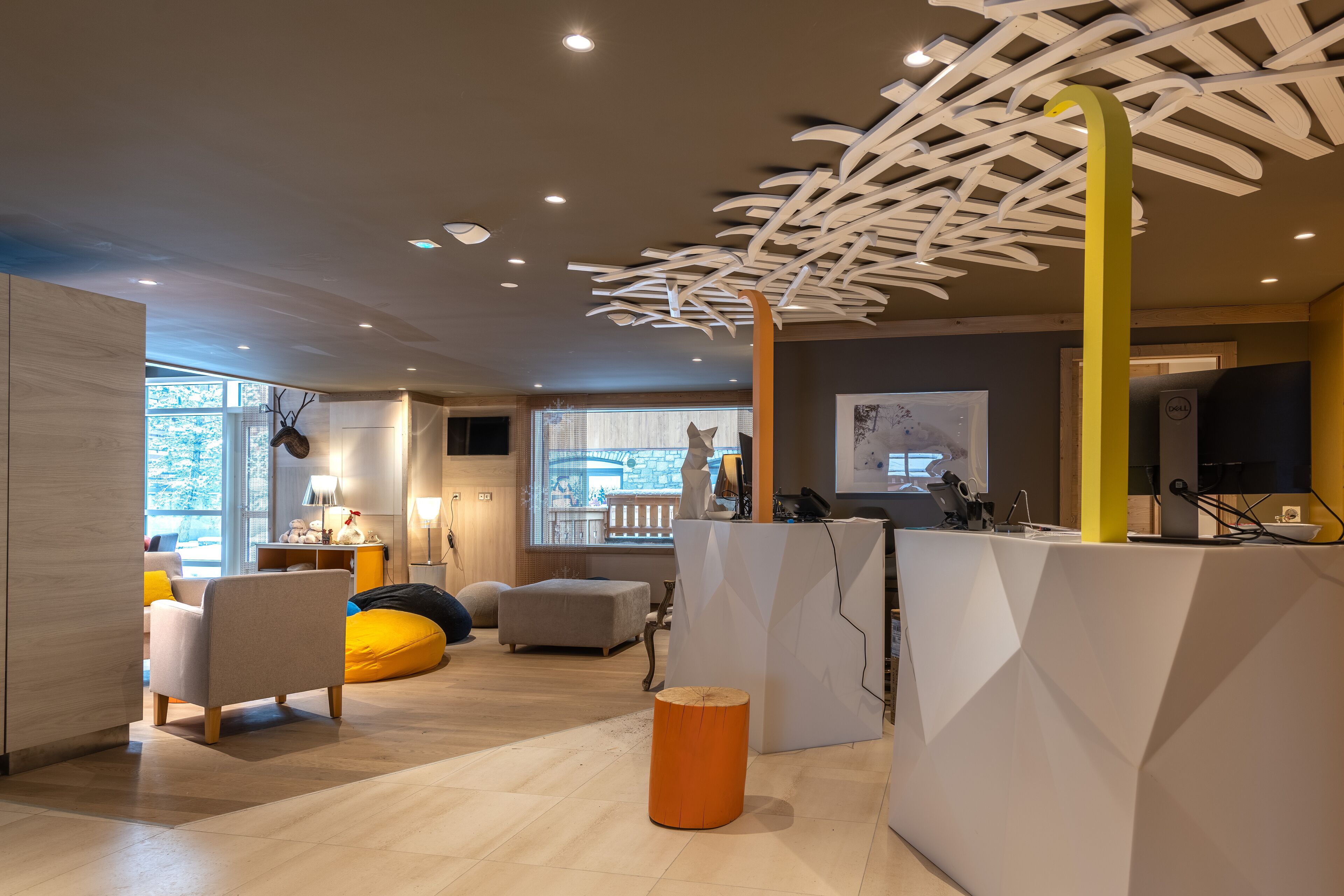 A modern interior with a reception desk, seating area, and large windows.