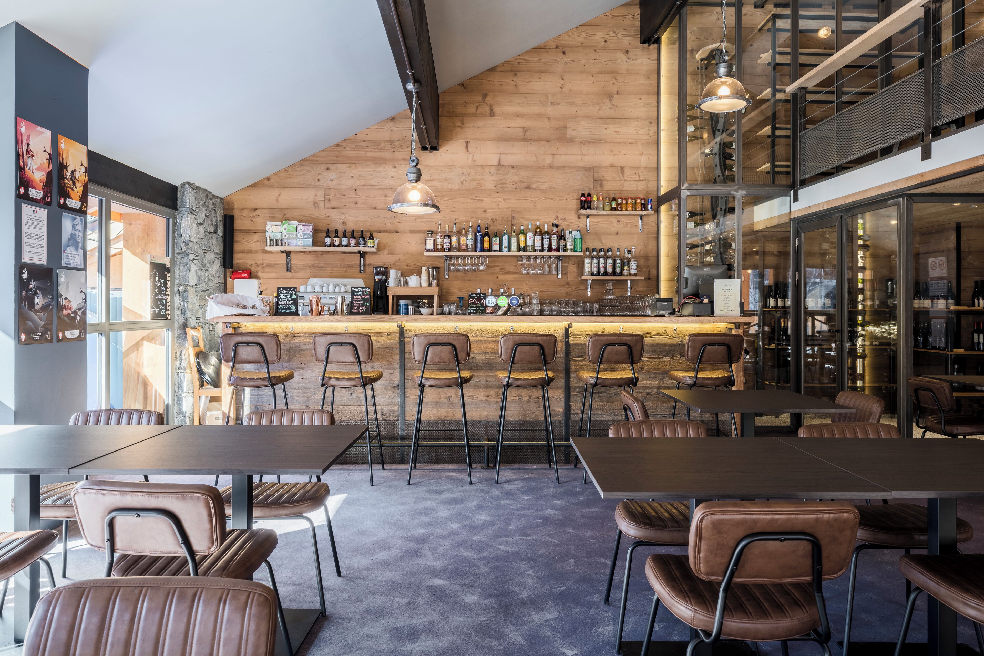 Un ristorante con zona bar, pareti in legno e poltrone in pelle.