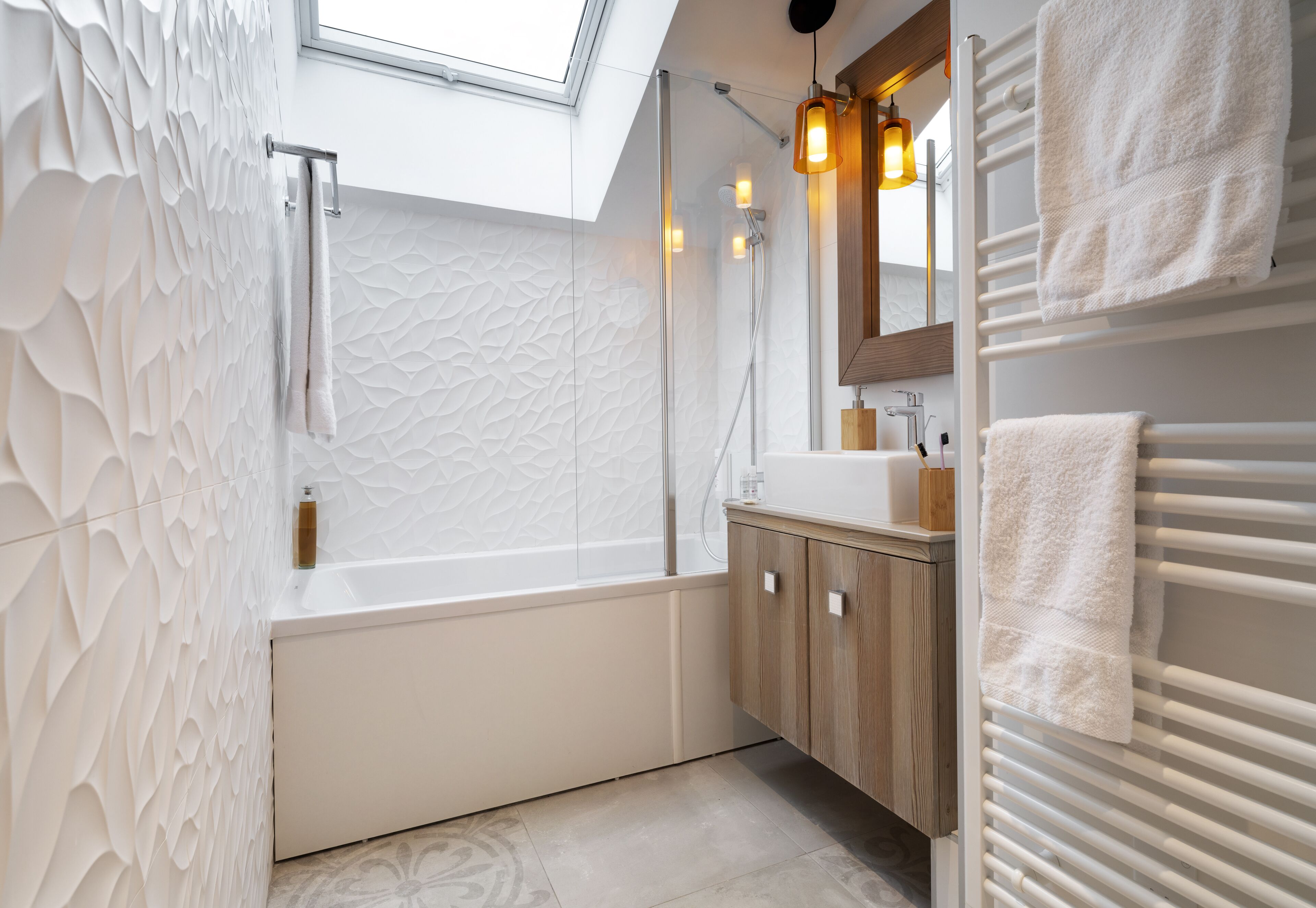 Un bagno moderno con vasca, doccia e un lucernario.