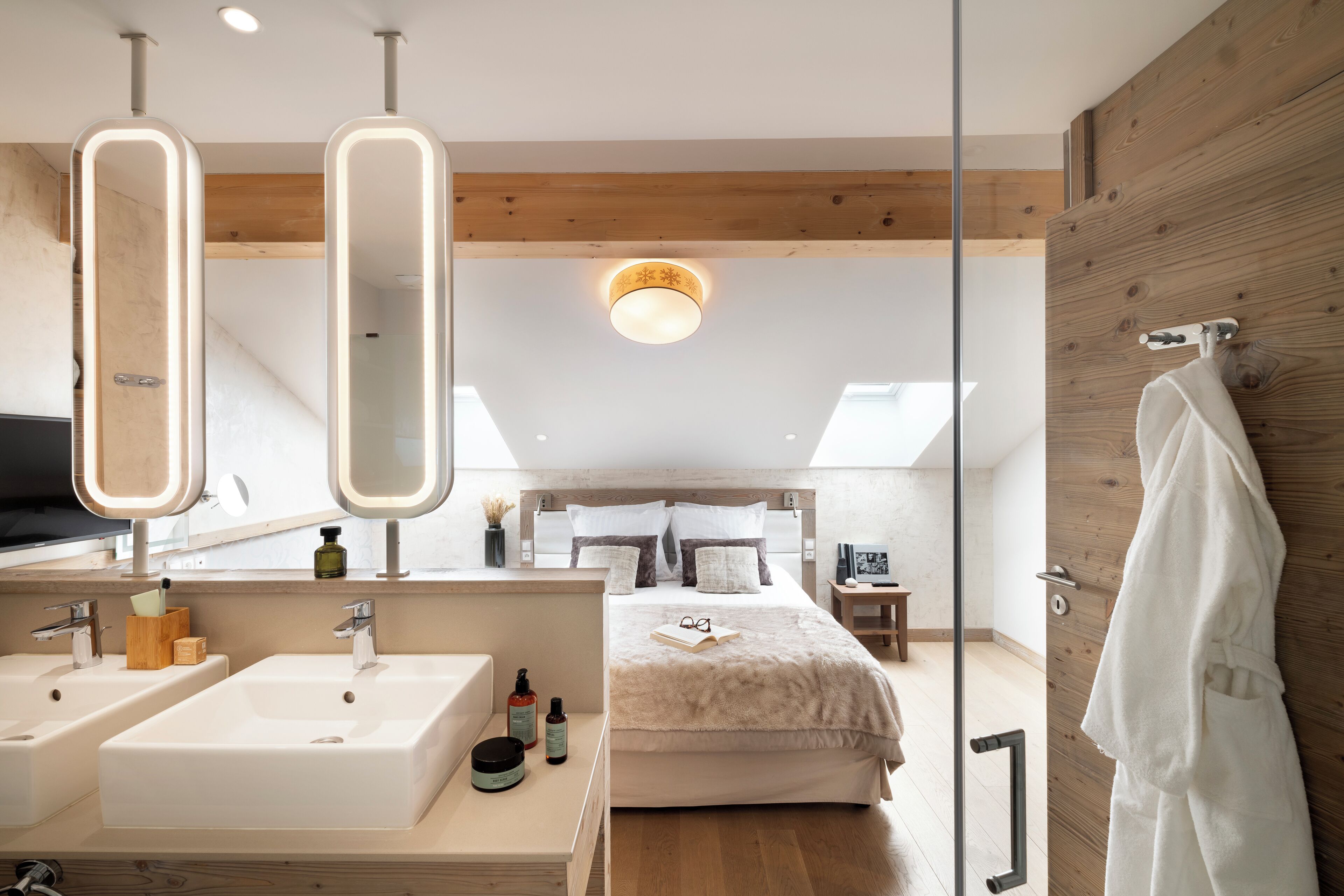 A modern bedroom with a large bed, two bedside tables, a nightstand, and a wooden wardrobe.