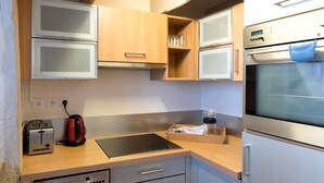 A compact kitchen with a built-in oven, a toaster, and a dishwasher. - Sunny Dussoubs I Unique 1-BR loft in Montorgueil (Paris)