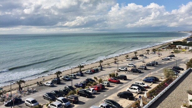 A coastal parking area with vehicles, a beach, and a clear sky. - ~ Beachfront 2 ~ view and direct access to the sea * ~ ¤ (Donville-les-Bains)