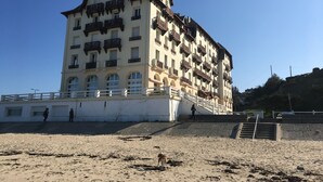 A multi-story hotel with balconies, a beach in the foreground, and a clear sky. - ~ Beachfront 2 ~ view and direct access to the sea * ~ ¤ (Donville-les-Bains)