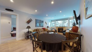 Ein modernes Wohnzimmer mit Kamin, Essbereich und einer gemütlichen Sitzecke.