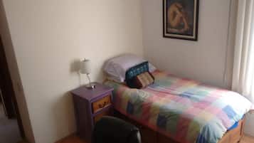 Habitación individual básica | Tabla de planchar con plancha y ropa de cama