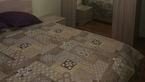 Une chambre à coucher avec un lit, une table de chevet, une armoire et un miroir.
