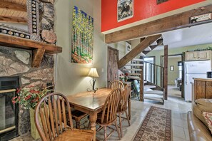 Cozy dining area with a fireplace and staircase, perfect for family meals.