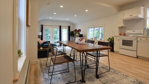Une cuisine spacieuse avec un coin repas, une table en bois et des appareils électroménagers modernes.