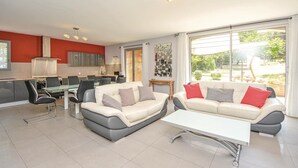 A modern living room with a dining area, large windows, and a kitchen. - Stunning home in Saint-Rémy-de-Provence (Saint-Rémy-de-Provence)