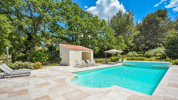 A swimming pool with a tiled deck, a small covered seating area, and lush greenery in the background. - Stunning home in Saint-Rémy-de-Provence (Saint-Rémy-de-Provence)