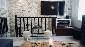 Relax in this inviting living room with a flat-screen TV, dark wooden bench, and a coffee table.
