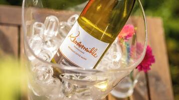 A bottle of wine in a glass container filled with ice cubes.