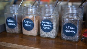 Four glass jars with metal straws, each labeled with a different name in a foreign language.